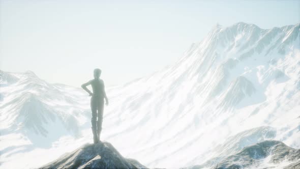 Woman Standing In Snow Wearing Warm Clothes In Mountains