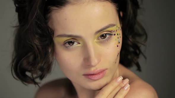 Young woman with star decorations on face