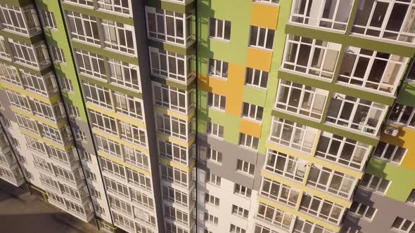Aerial footage of a tall residential apartment building with many windows and balconies.