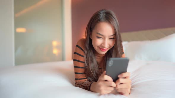 Young asian woman use smart phone in room