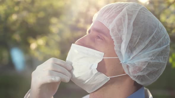 Physician Takes Off a Surgical Mask and Sighs