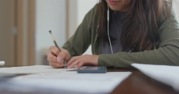 Woman write on the note do revision at home