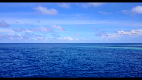 Aerial flying over seascape of relaxing shore beach break by turquoise ocean with white sand backgro