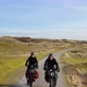 Man and woman riding bikes on dirt road, Nes, Friesland, Netherlands - VideoHive Item for Sale