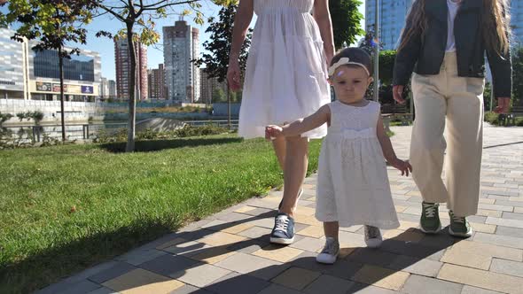 Adorable Baby Girl Learning To Walk in Urban Park