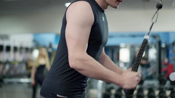 Side View of Unrecognizable Masculine Young Man Training Hand Muscles in Gym Indoors