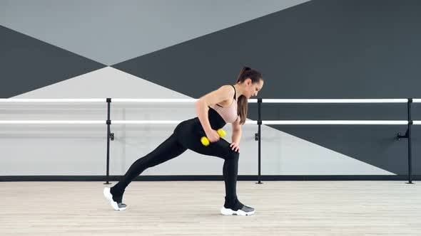 Woman Training Back Using Dumbbells