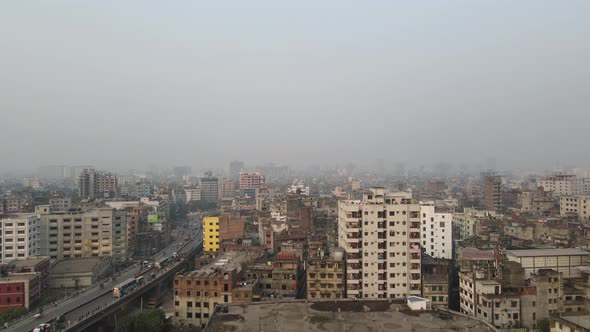 Bird's-eye View of the Dhaka city in Bangladesh with densely populated buildings and flyover with tr