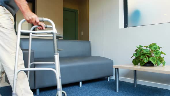 Patient helping himself to have a sit thanks to his zimmer frame