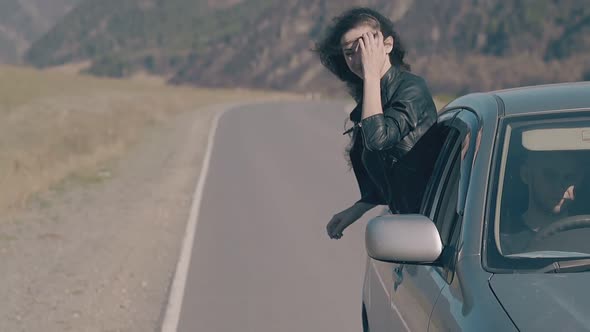 Wind Plays with Pretty Young Woman Hair Driving in Car