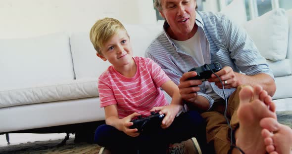 Father and son playing video game in living room 4k
