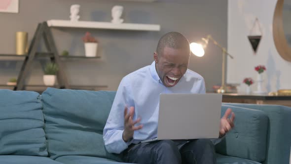 African Man Feeling Shocked While Using Laptop