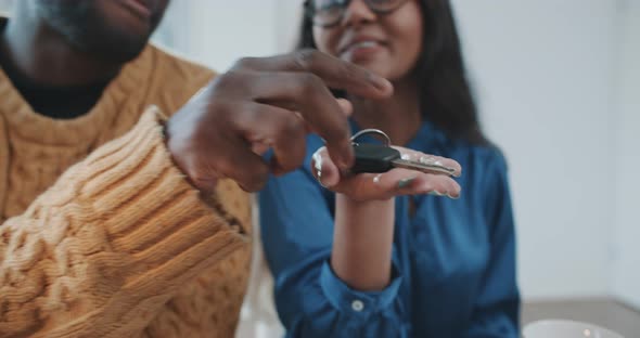 Multiethnic couple receiving keys for new car