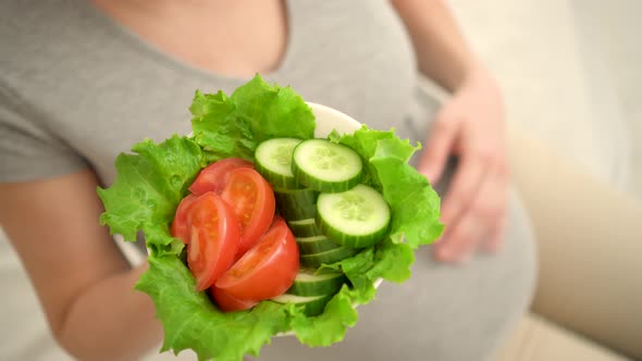 Pregnant Woman is Holding Fresh Vegetables in Her Hand