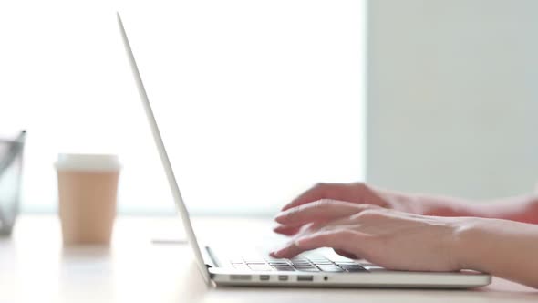 Side View of Indian Woman Typing on Laptop Keyboard