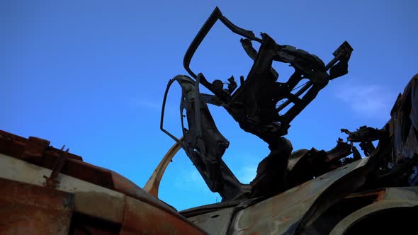 Ruined Bombed Car Door at Background of Blue Summer Sky Outdoors