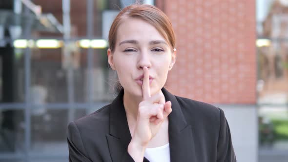 Silence Please, Finger on Lips by Young Businesswoman