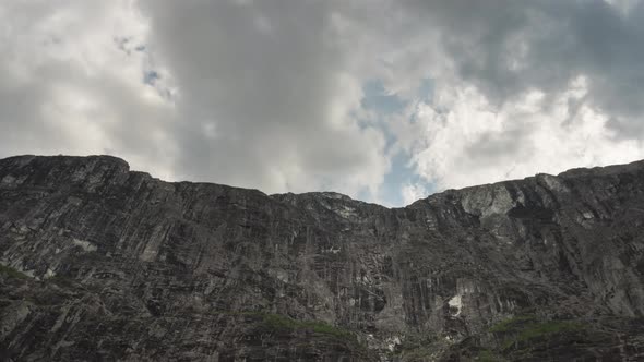 Dramatic upwards time-lapse of cloudsing over imposing cliff-face
