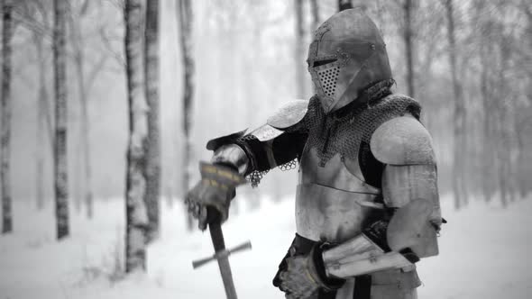 Portrait of Brave Warrior Wearing Steel Armor and Helmet Preparing for Swordfight on Battlefield in