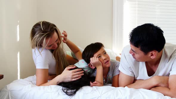 Happy family relaxing on bed