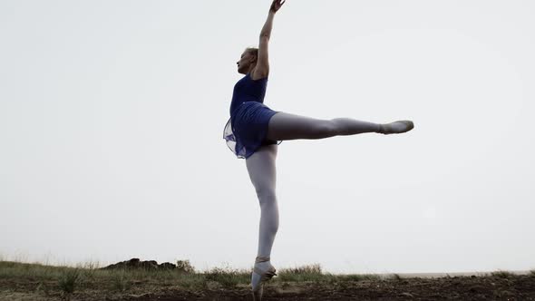 Professional dancer jumps up and starts spinning in pointe shoes, outdoor. Caucasian ballerina dance
