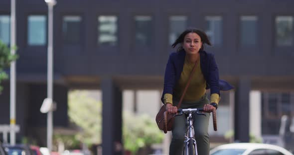 African american woman riding bicycle in street