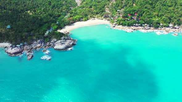 Tropical overhead copy space shot of a white sandy paradise beach and blue water background in 4K