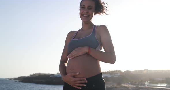 Young pregnant woman doing yoga outdoor - Sport exercises and maternity concept