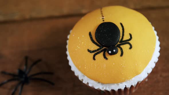 Halloween spider cupcake on a wooden table 4k