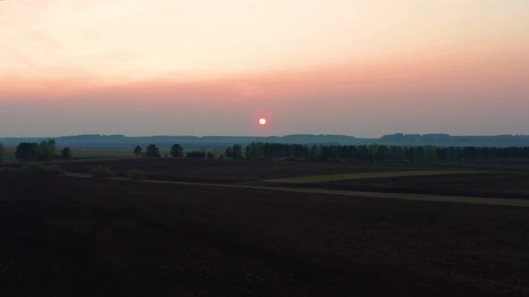 Aerial View of the Red Sunset Over the Forest