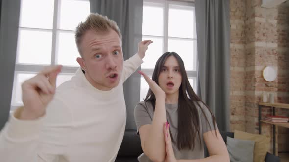 Ecstatic Young Couple Dancing and Singing before Camera