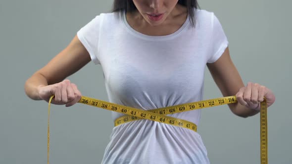 Asian Woman Measuring Waist With Tape-Line, Happy About Weight Loss Diet Concept