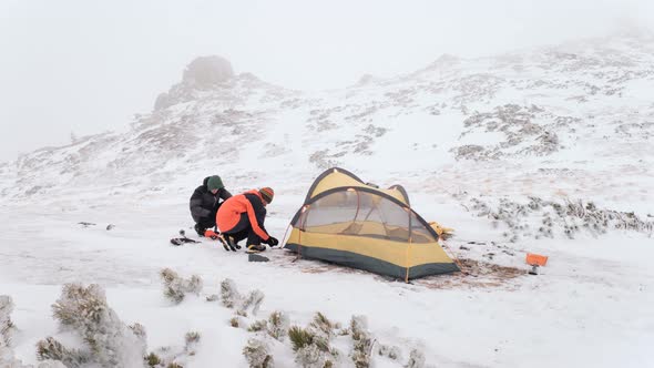 Tourist Put Up Tent in Winter Mountains While Hiking