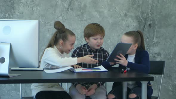 Three Little Children on Business Meeting Sharing Ideas in Office, Using Tablet and Documents