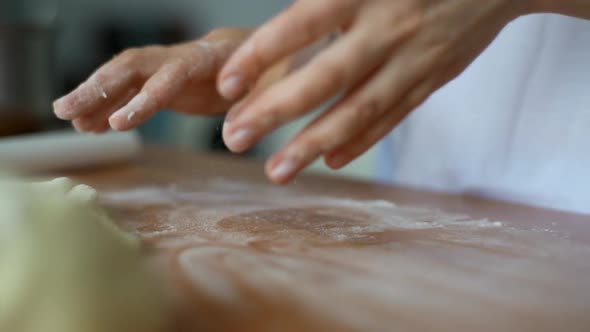 Woman Rolls the Dough with a Rolling Pin Shaping the Dough