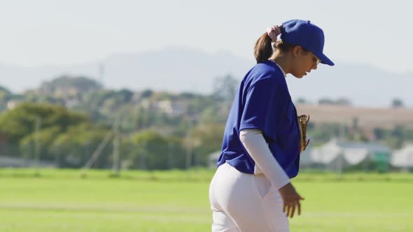 Disappointed caucasian female baseball player holding head and kicking on field after losing a game