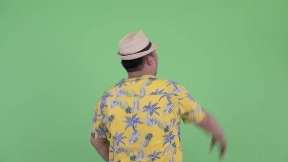Rear View of Happy Young Overweight Asian Tourist Man Pointing Finger