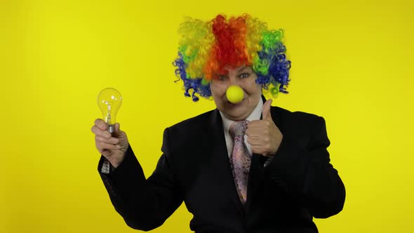 Elderly Clown Businesswoman in Wig Show Light Bulb. Came Up with Great Idea