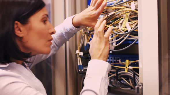 Technician checking cables in a rack mounted server