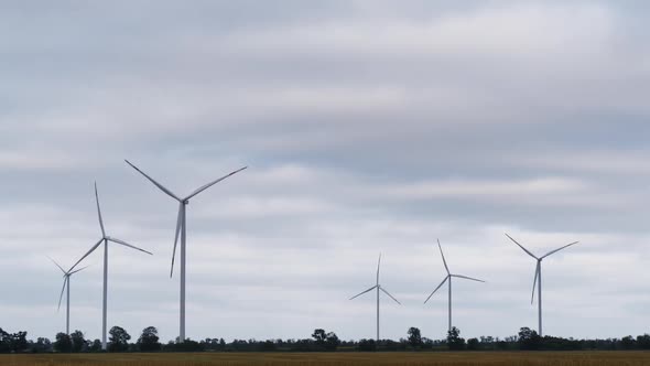 Windmill Turbines Rotating Propellers in Time Lapse Against Sunset Cloudy Sky in the Evening