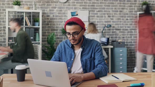 Zoom Out Time-lapse of Male Employee Working with Laptop Busy with Project