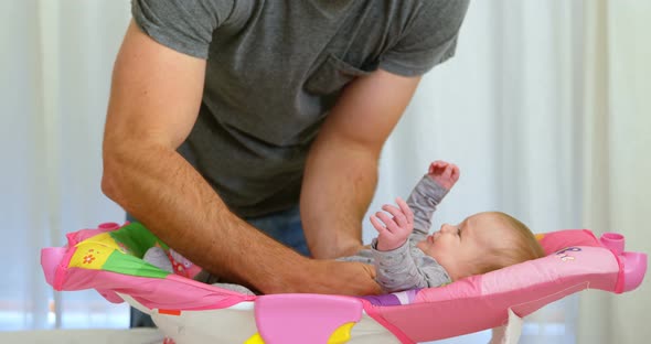 Father putting his baby on baby boy bed 4k