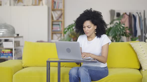 Portrait of a Young African American Woman Typing on Laptop Keyboard