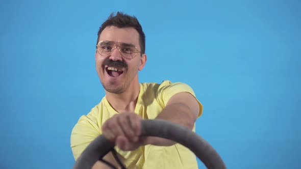 Portrait of a Funny Male Driver with a Mustache at the Wheel