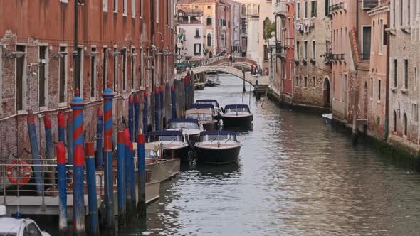 Narrow Canals of Venice with Gondolas Parked on Water Between Colorful Houses