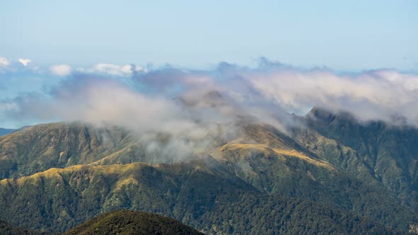 Foggy Clouds Moving over Mountains Ridge in Tararua Range Forest Park in New Zealand