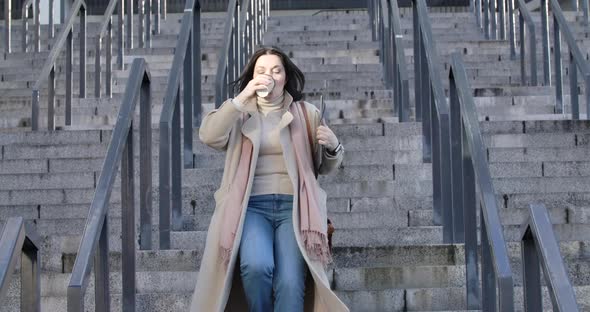 Adult Caucasian Woman Drinking Coffee As Running Down the Stairs and Looking at Her Watch. Young