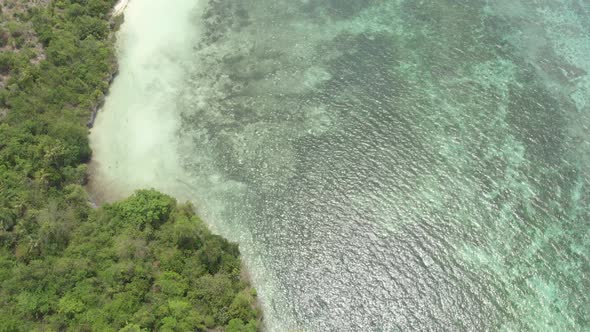 Aerial: Flying over tropical beach turquoise water coral reef , Tomia island Wak