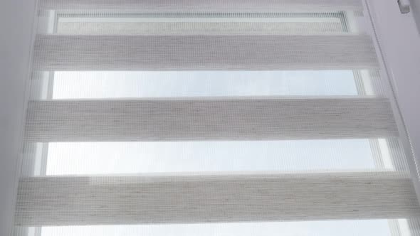 The mechanism of tnaninny roller blinds close up. Duo window roller system day and night.