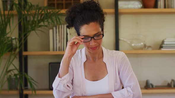 Caucasian woman talking to camera on video call, working from home